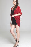 Model wearing short red chiffon kimono facing left